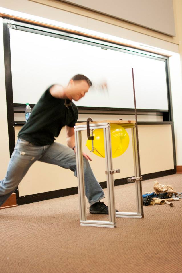 inspirational speaker drives nails through wooden boards during a motivational speech for a college